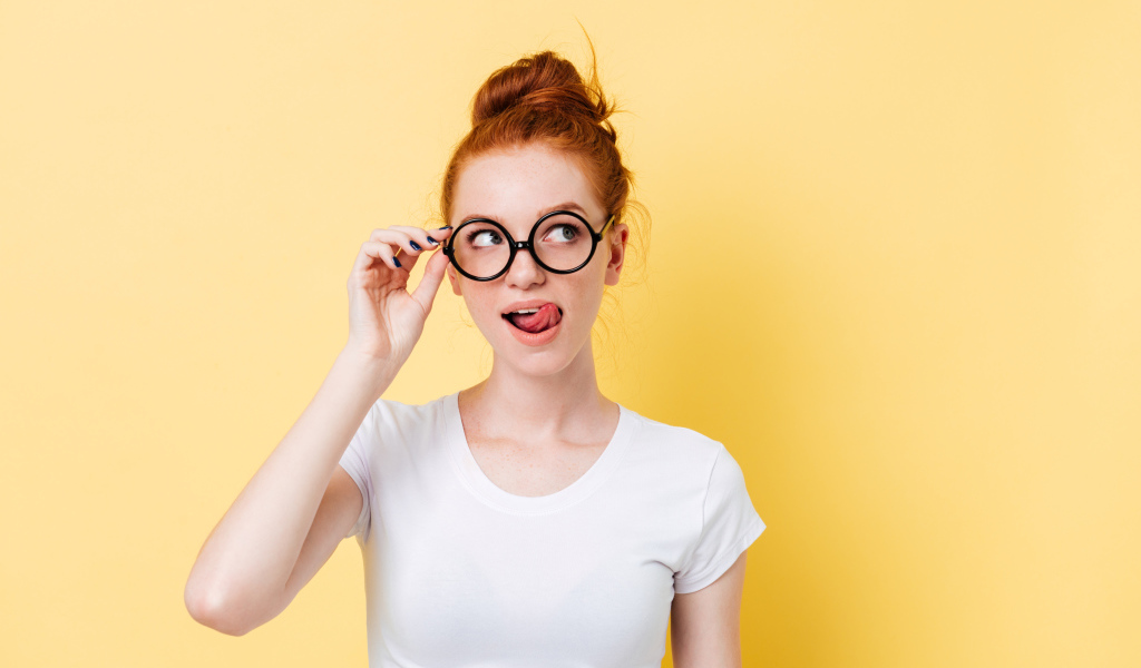 Красивая девушка в очках на желтом фоне 