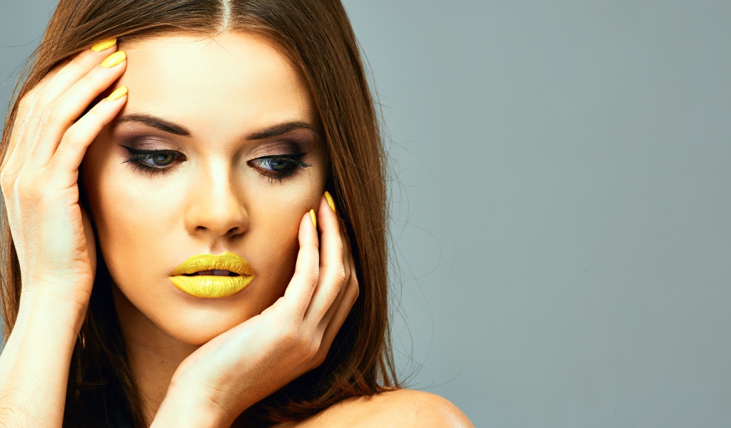 Красивая девушка с желтыми губами на сером фоне