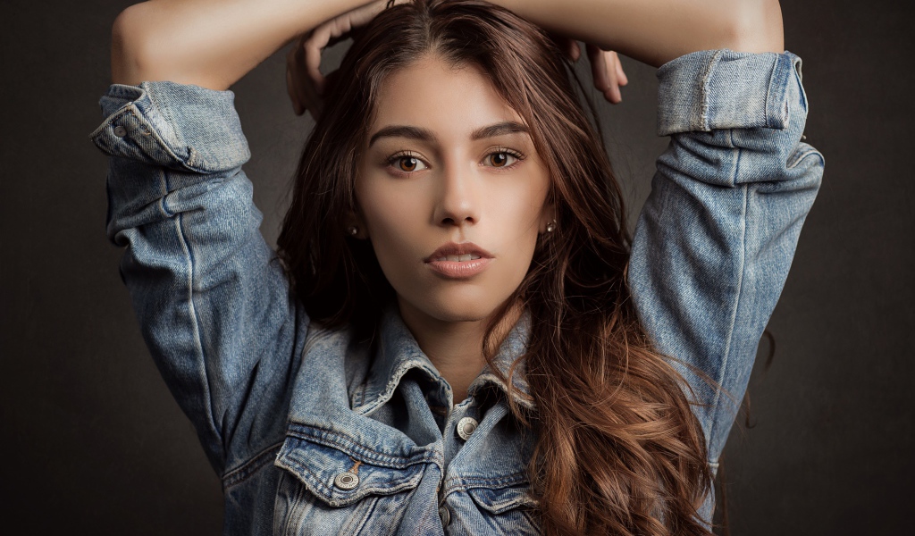 Красивая длинноволосая шатенка в джинсовой куртке 