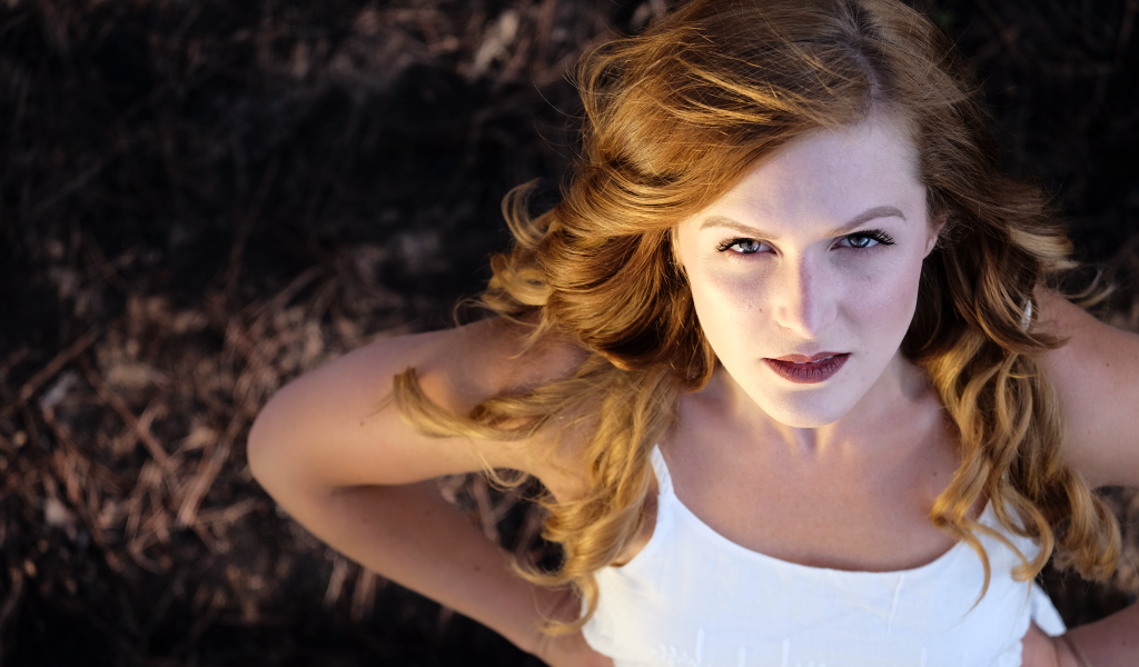 Красивый взгляд рыжеволосой девушки в белом платье