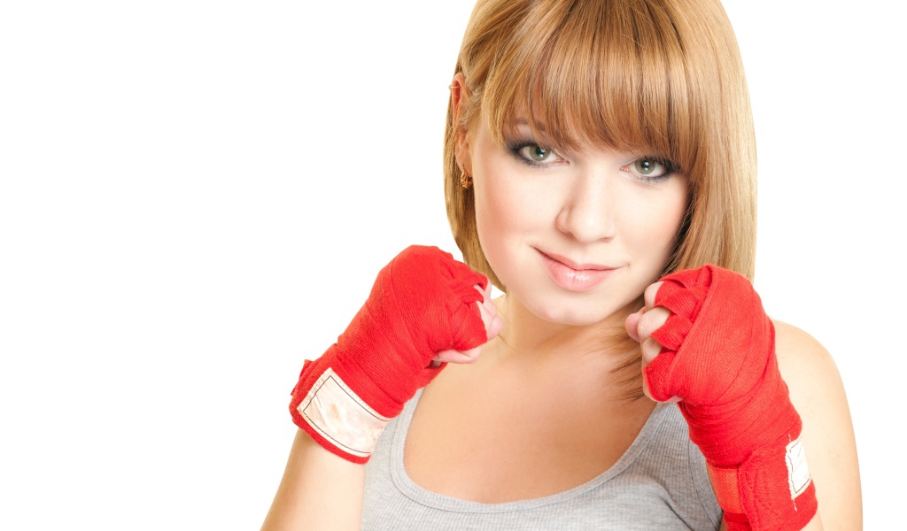 Красивая рыжеволосая девушка в стойке боксера на белом фоне