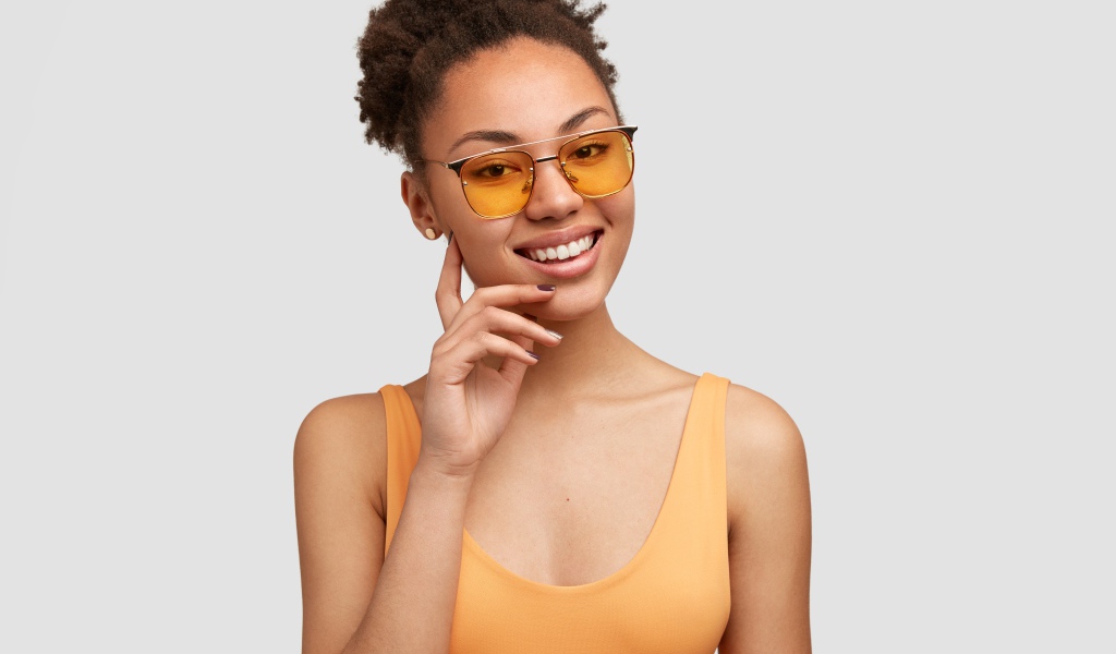 Красивая улыбающаяся темнокожая девушка в солнечных очках
