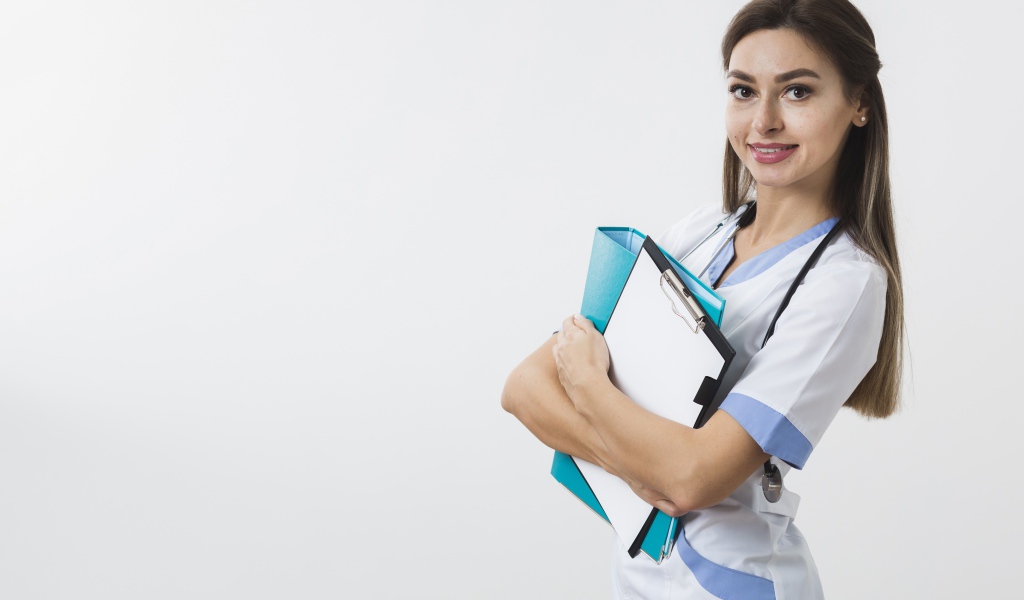 Красивая улыбающаяся девушка врач с папками на белом фоне 