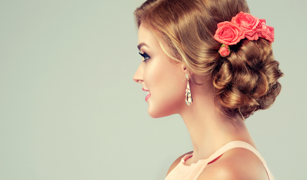Красивая свадебная прическа у молодой девушки на сером фоне 