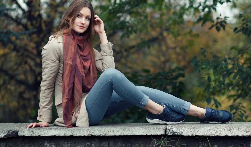 Милая девушка в куртке и синих джинсах 