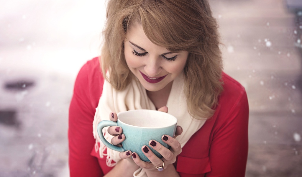 Милая девушка согревается горячим кофе