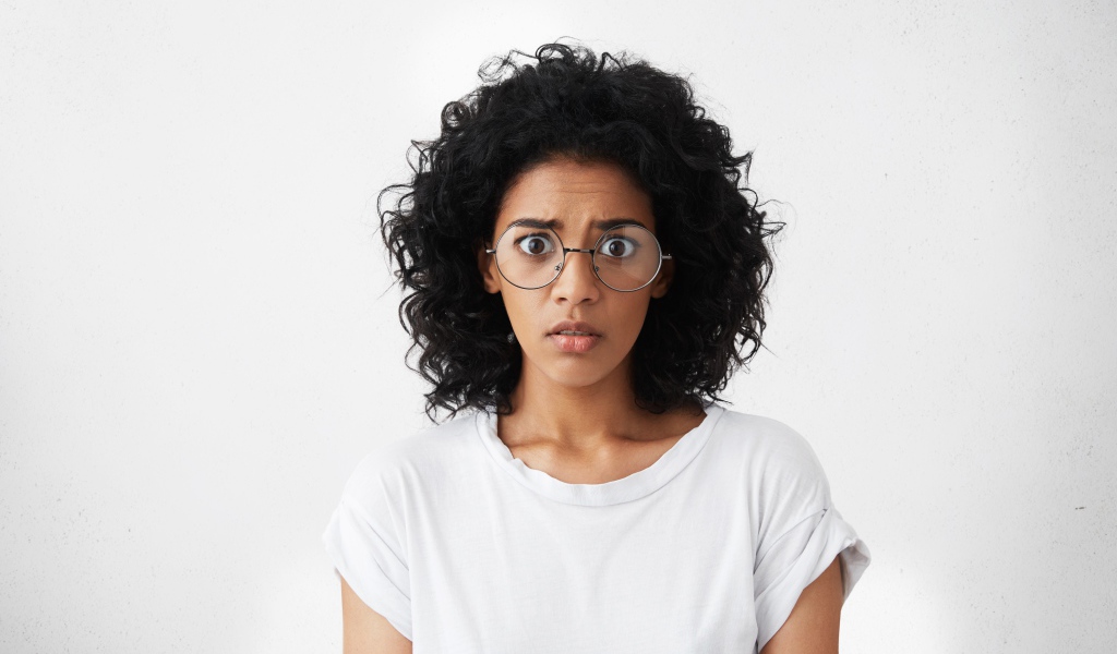 Темноволосая девушка в белой футболке на сером фоне