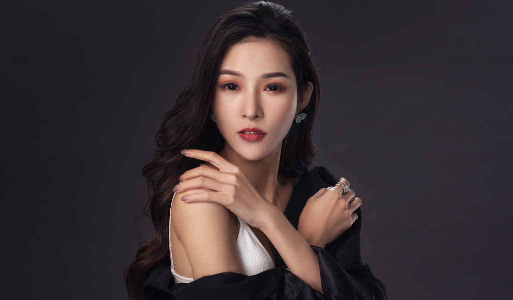 Нежная длинноволосая азиатка на сером фоне