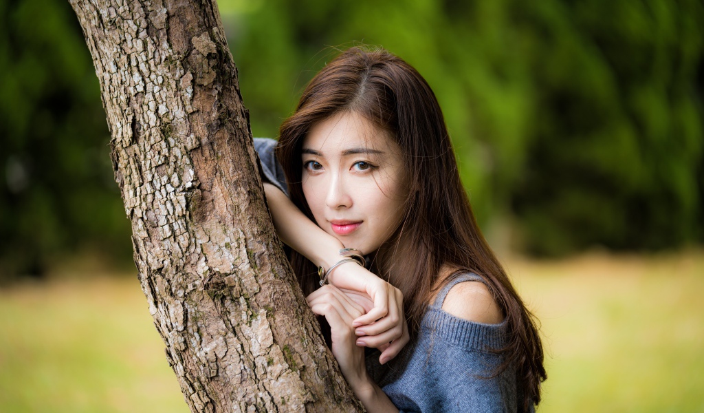 Dreamy Asian girl stands by the tree