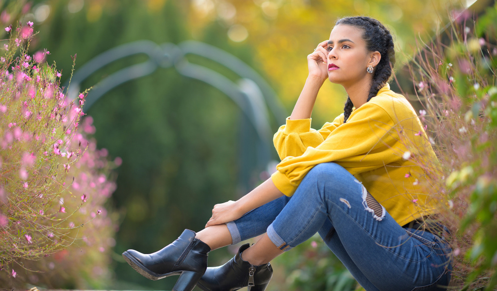 Девушка в джинсах сидит на земле 