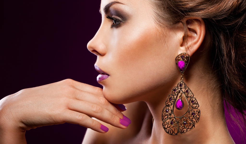 Лицо девушки с красивым макияжем и дорогими серьгами