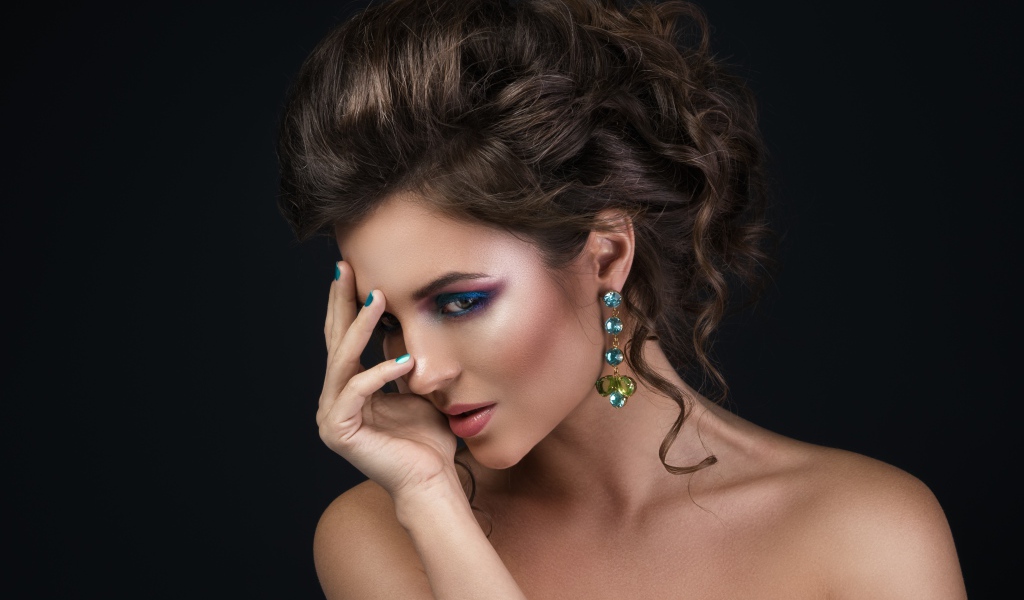 Девушка с красивой вечерней прической на сером фоне