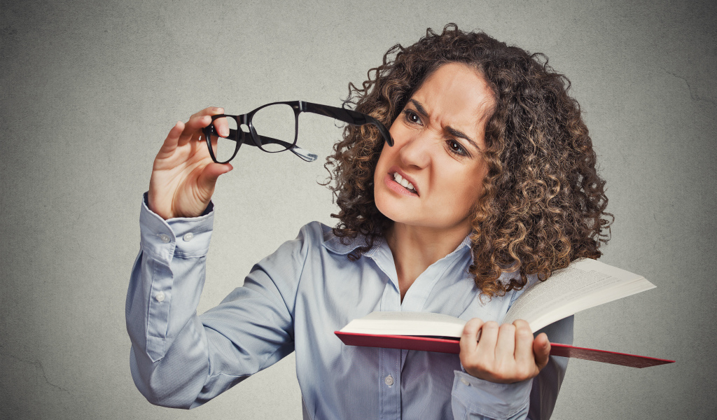 Девушка с книгой с очками в руке