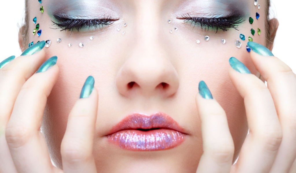 Девушка  с ярким макияжем и стразами на лице 