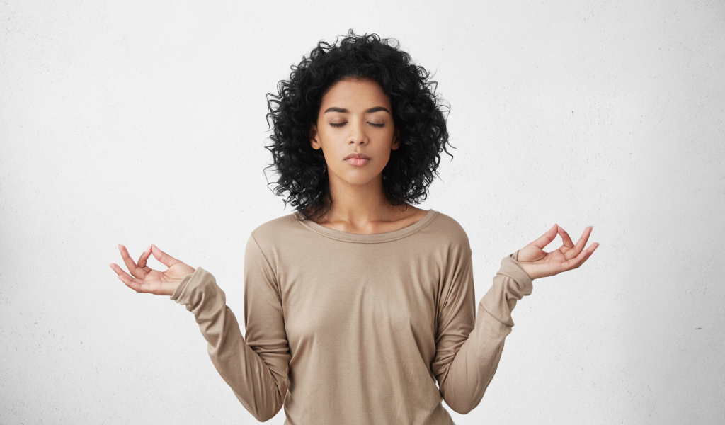 Девушка с закрытыми глазами медитирует 