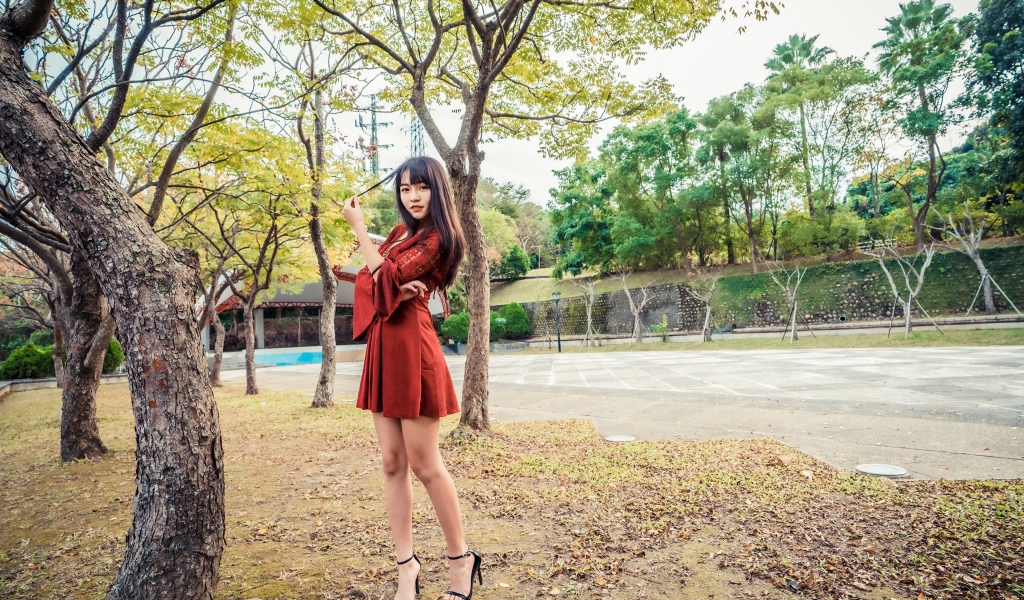 Длинноногая девушка азиатка в коротком красном платье 