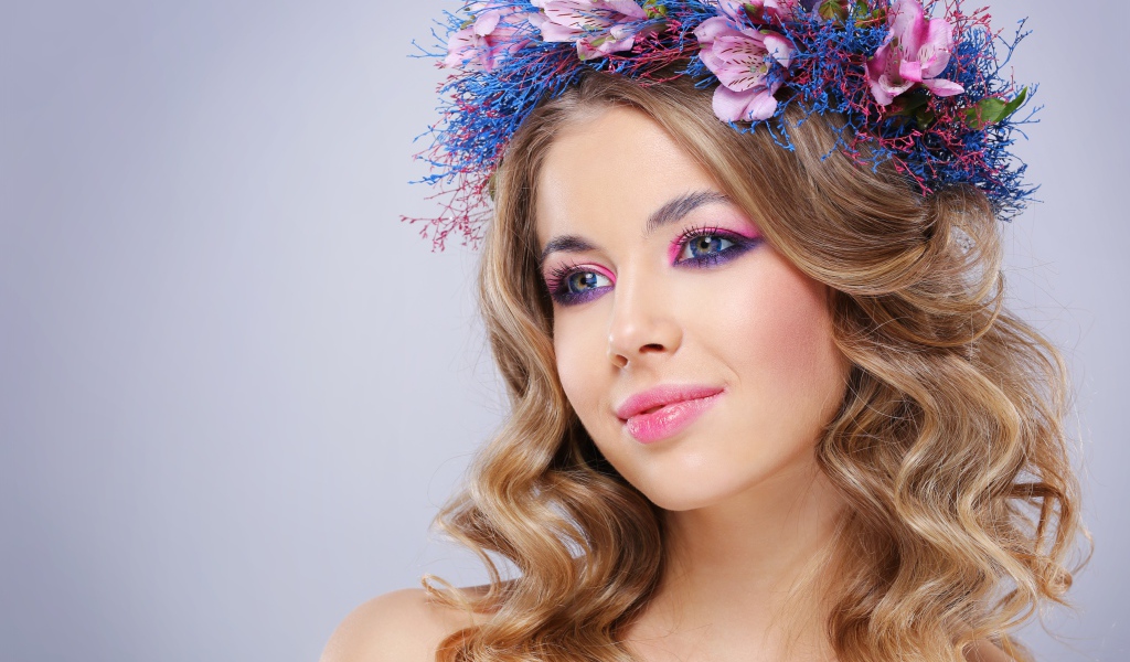 Милая девушка с венком на голове на сером фоне 