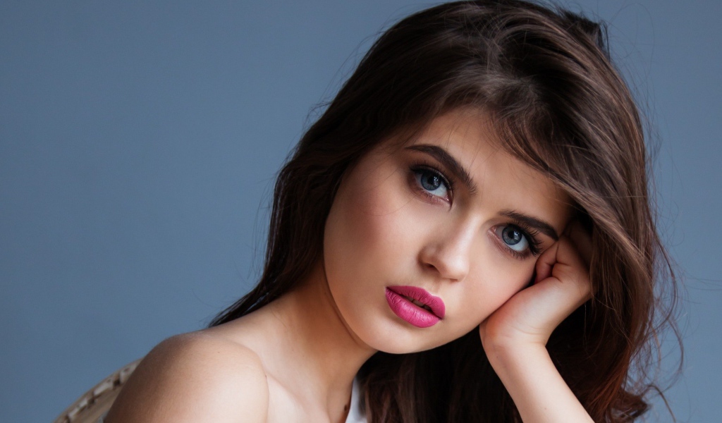 Милая девушка с розовыми губами на сером фоне