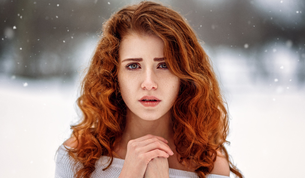 Рыжеволосая девушка замерзает на улице зимой