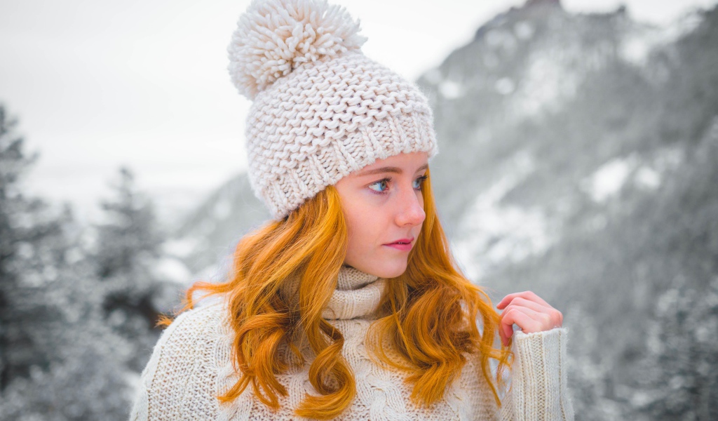 Рыжеволосая девушка в теплой шапке зимой 