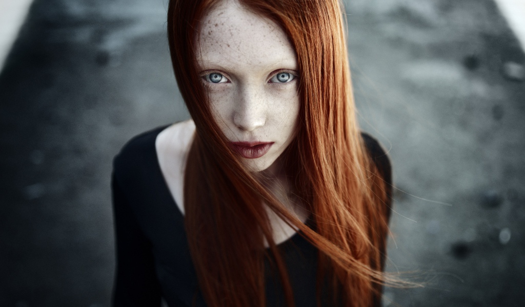 Рыжая длинноволосая девушка с веснушками на лице