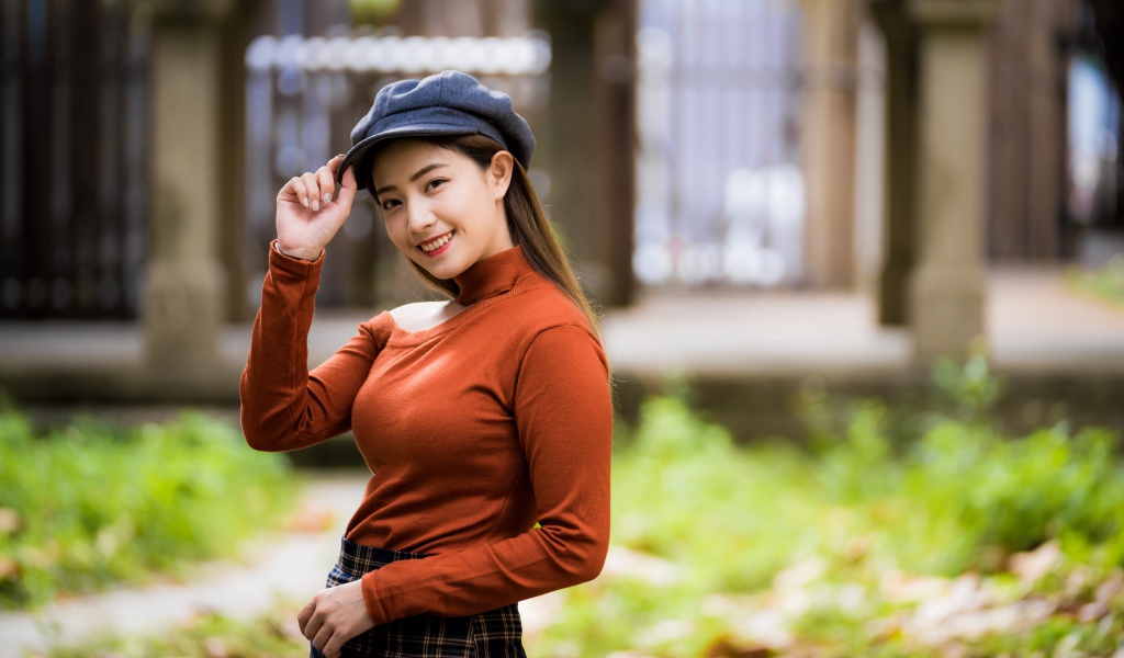 Улыбающаяся девушка азиатка в кепке 