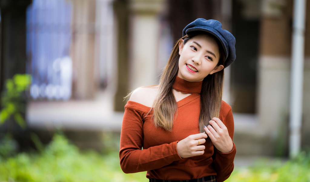 Улыбающаяся азиатка в черной кепке 