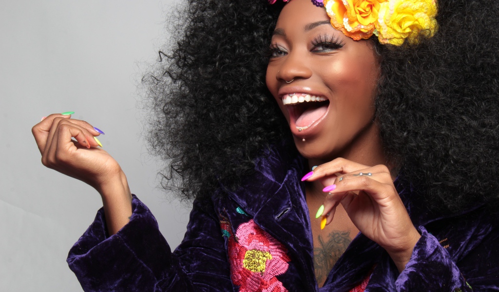 Улыбающаяся темнокожая девушка с цветами в волосах 