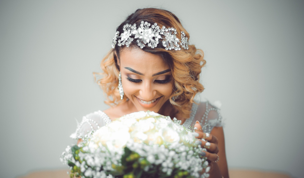 Улыбающаяся девушка невеста с букетом цветов 