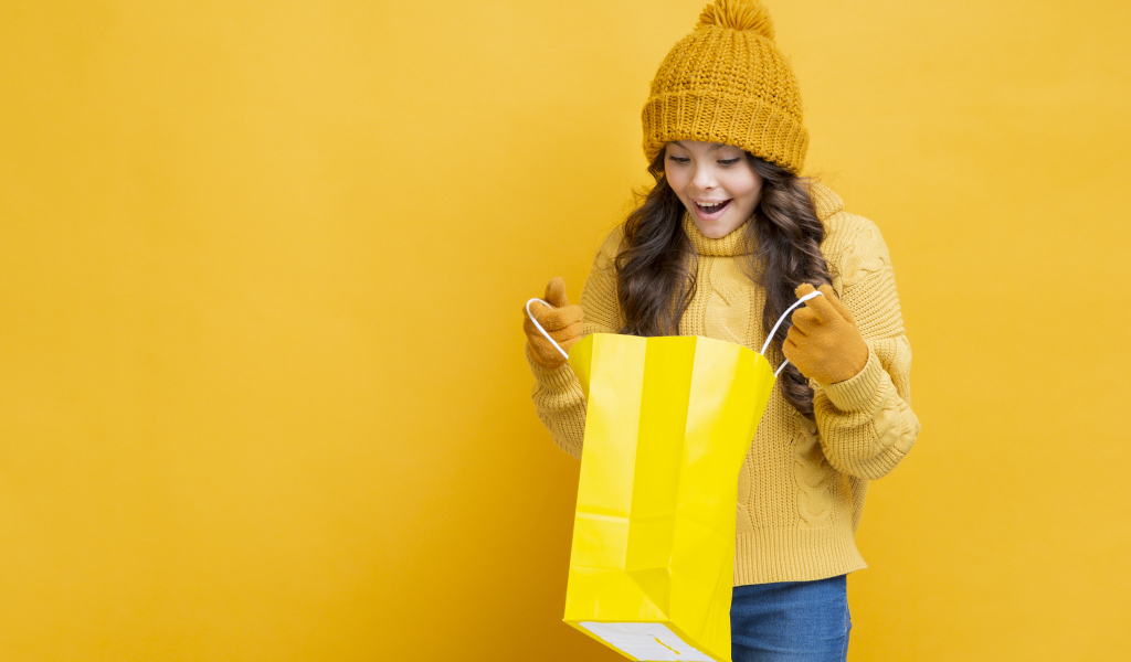 Улыбающаяся девушка в теплом свитере  с пакетом в руках 