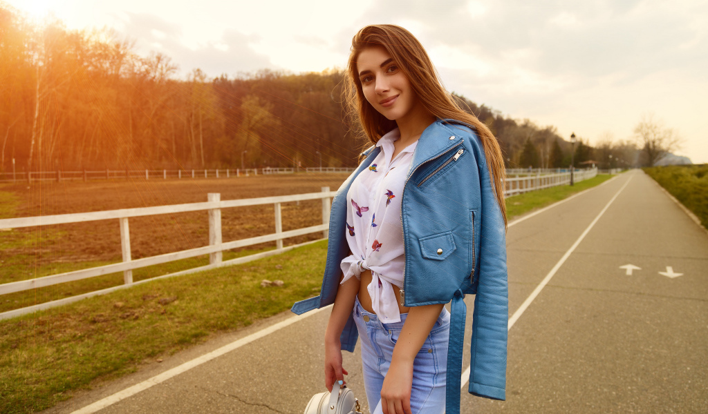 Smiling girl in blue leather jacket on the road