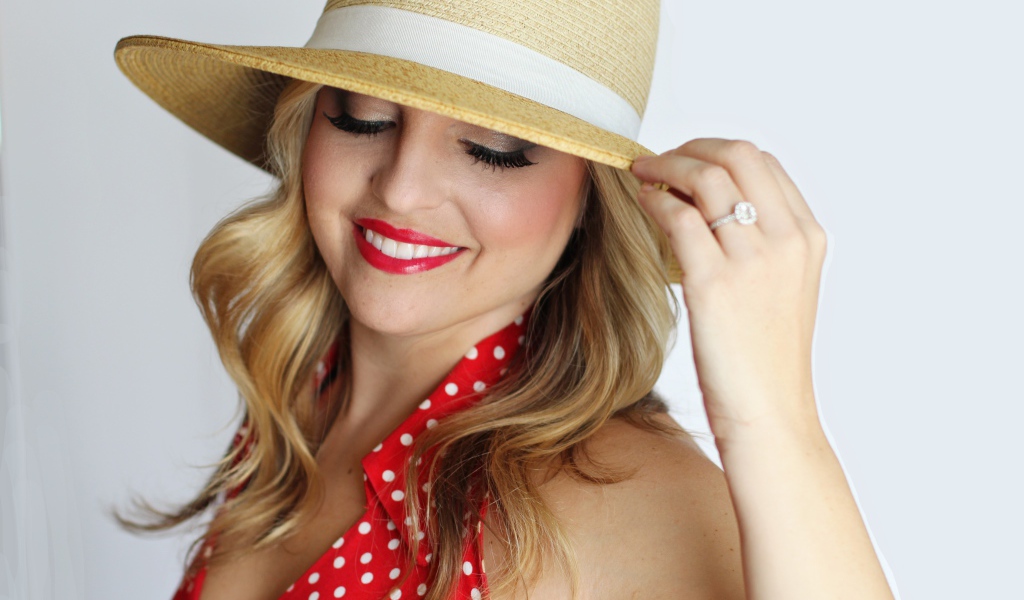 Улыбающаяся девушка в шляпе на белом фоне