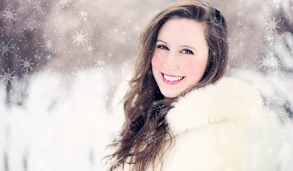 Улыбающаяся девушка в белой шубе на улице зимой 