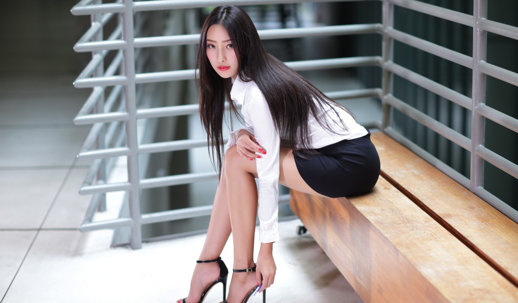 Стильная деловая девушка азиатка сидит  на лавке