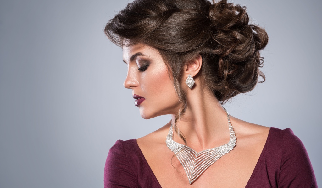 Стильная женщина с вечерней прической, макияжем и дорогими украшениями
