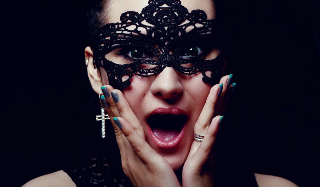 Удивленная девушка в черной маске на лице