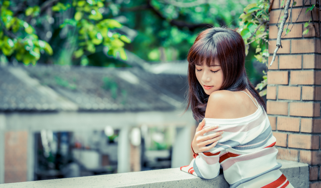 Нежная азиатка стоит на балконе