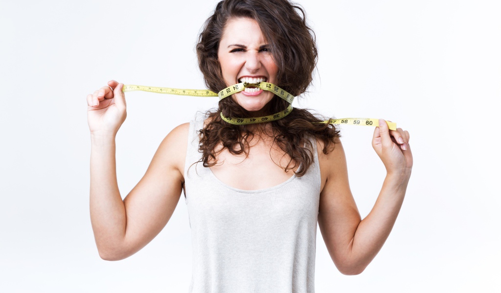 Блондинка в белой майке грызет сантиметр 