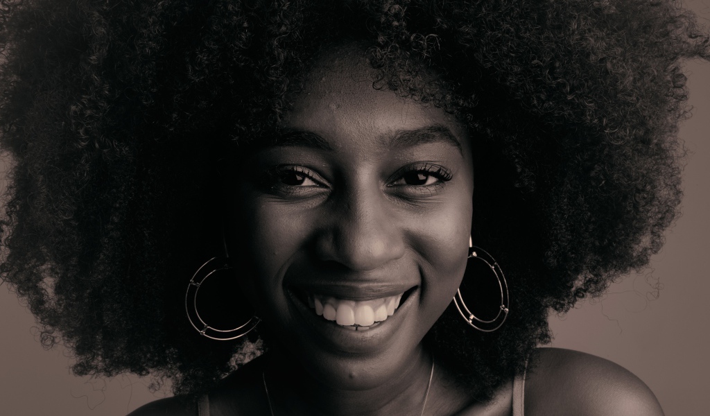 Лицо улыбающейся темнокожей девушки  