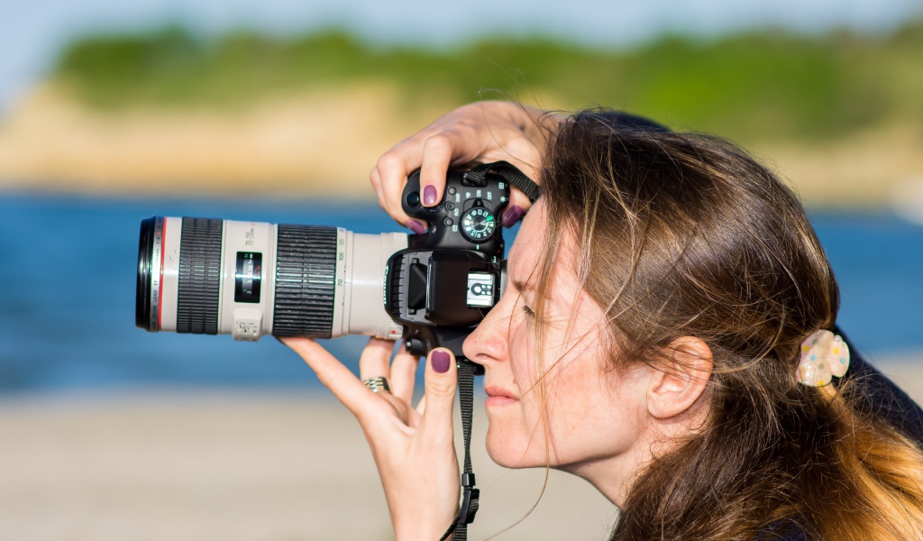 Девушкой делает фото на фотоаппарат 