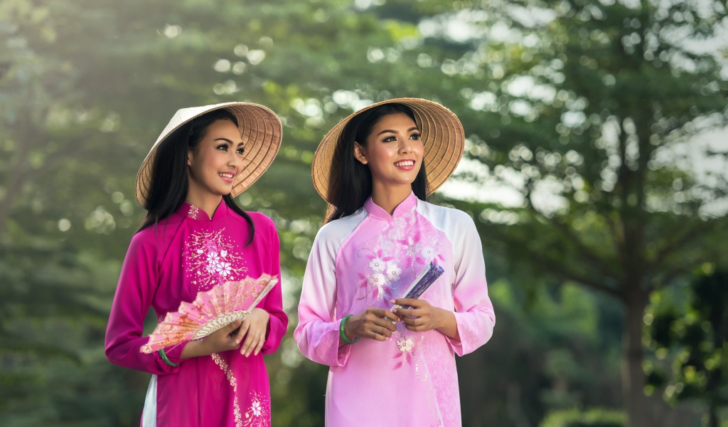 Две девушки азиатки в платьях с веером в руках