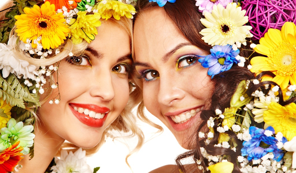 Две яркие улыбающиеся девушки с цветами в волосах 