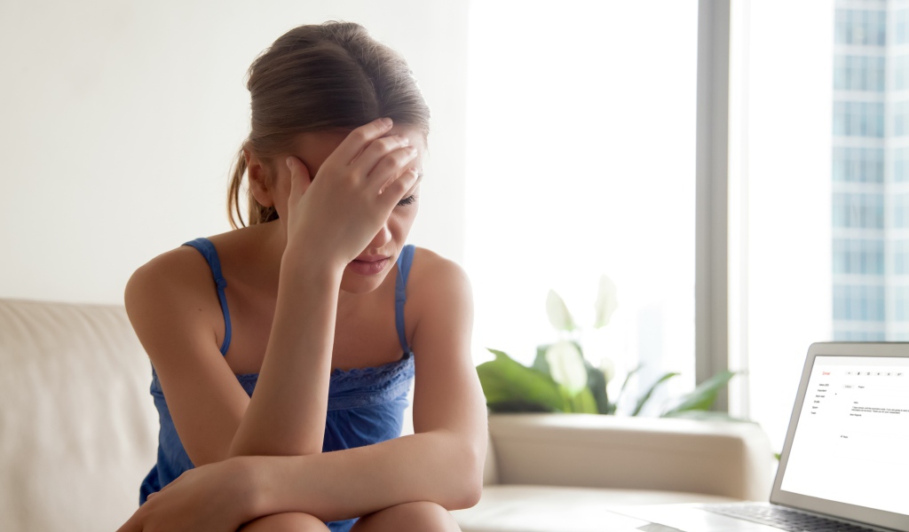 Расстроенная молодая девушка с ноутбуком