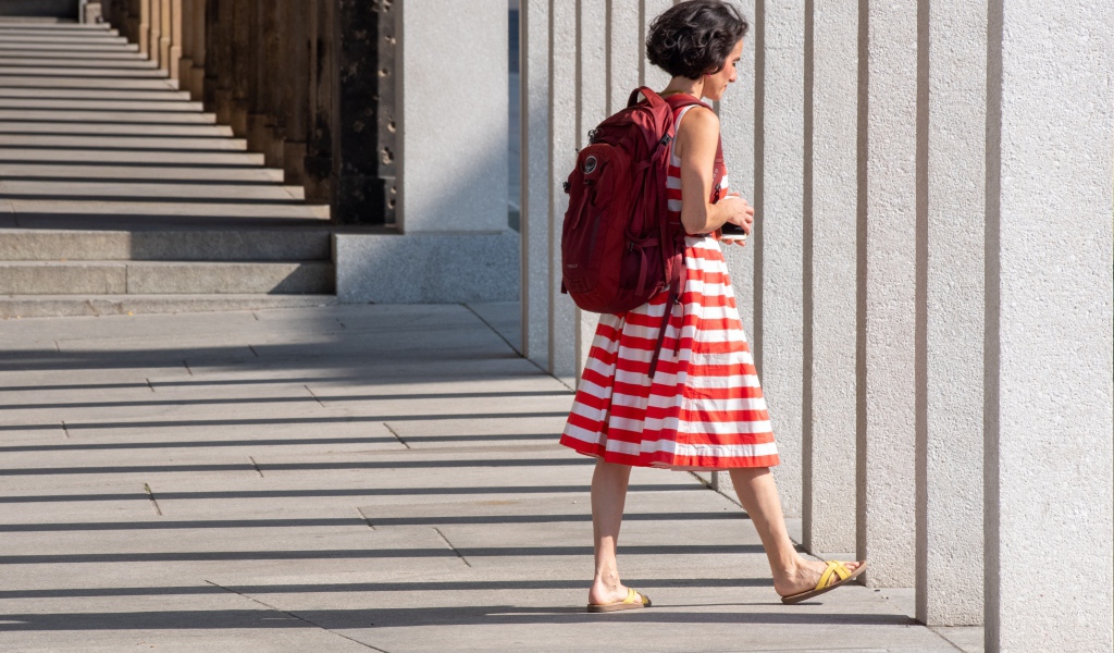 Женщина в красном полосатом платье с рюкзаком