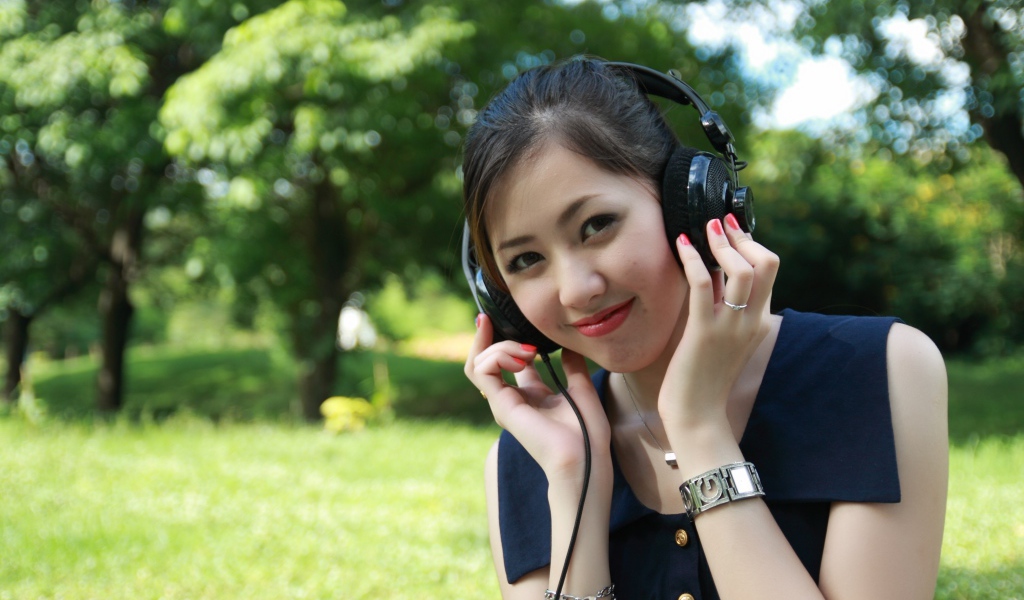 Молодая девушка азиатка в больших наушниках 