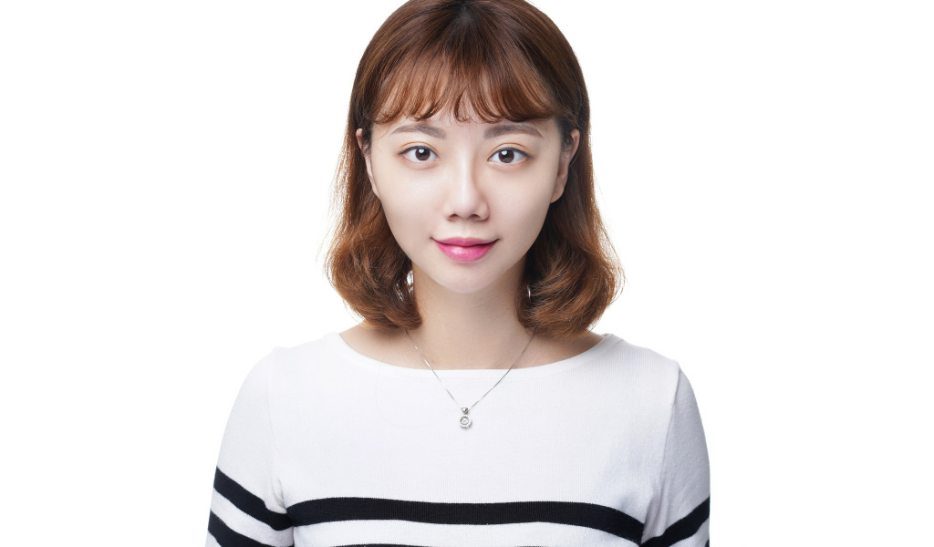 Молодая азиатка в свитере на белом фоне