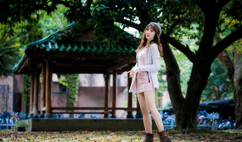 Молодая азиатка в теплой кофте в парке