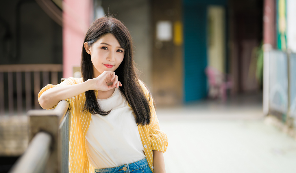 Молодая азиатка в белой майке и полосатой рубашке 