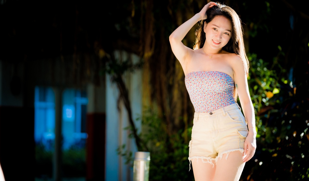 Молодая азиатка в шортах в лучах солнца