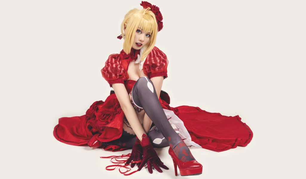 Молодая азиатка в ярком красном костюме на белом фоне